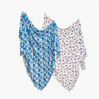 Two baby swaddle blankets, one blue with animal pattern and one purple with floral pattern, on a white background.