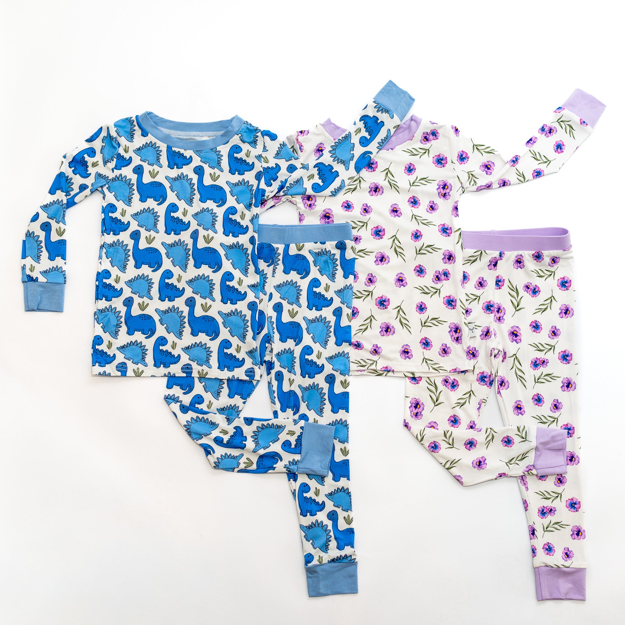 Children's pajama set with dinosaur pattern and floral pattern on a white background.