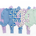 Set of colorful baby bamboo rompers on a white background.