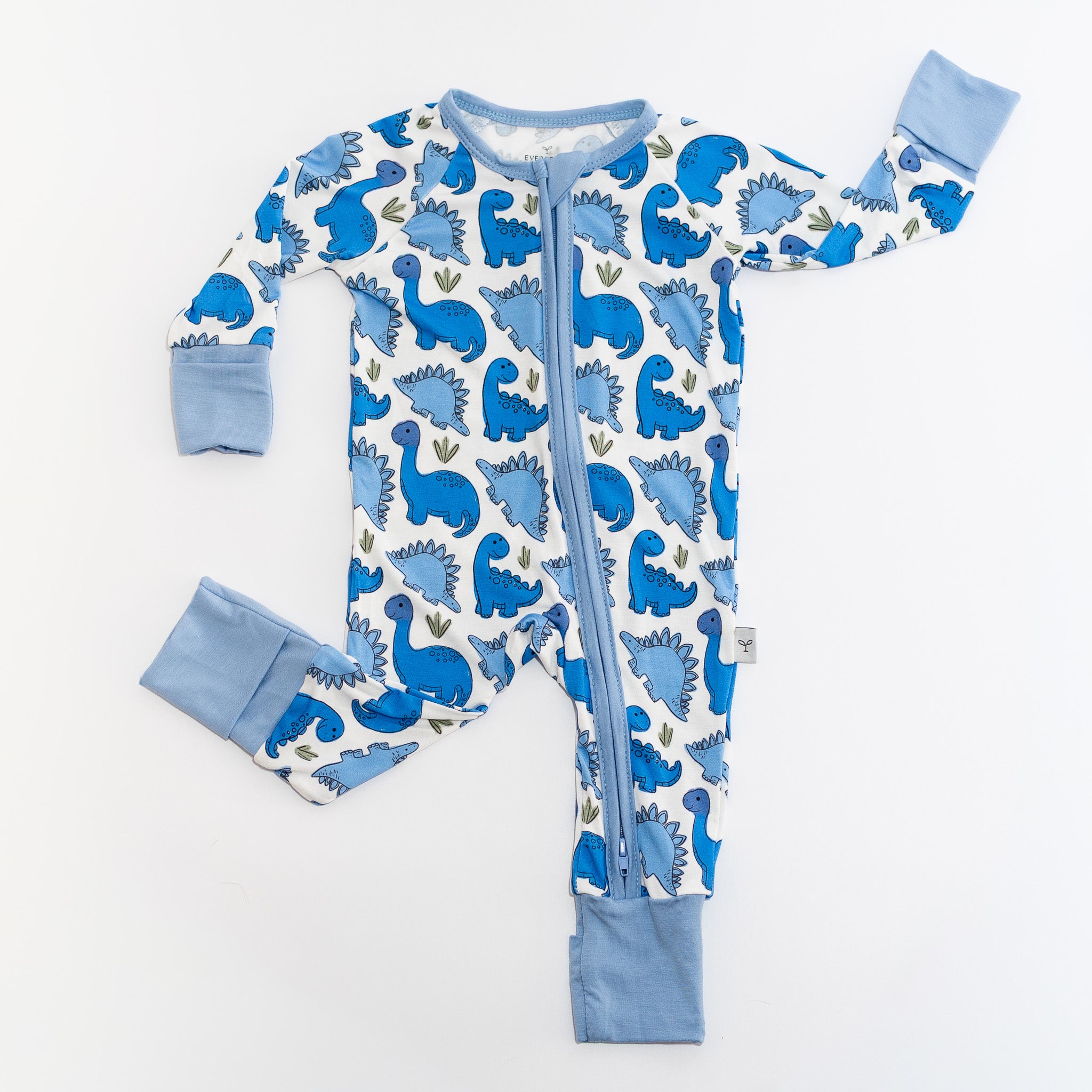 Pattern of blue dinosaurs on white bamboo fabric pajamas kids convertible romper.
