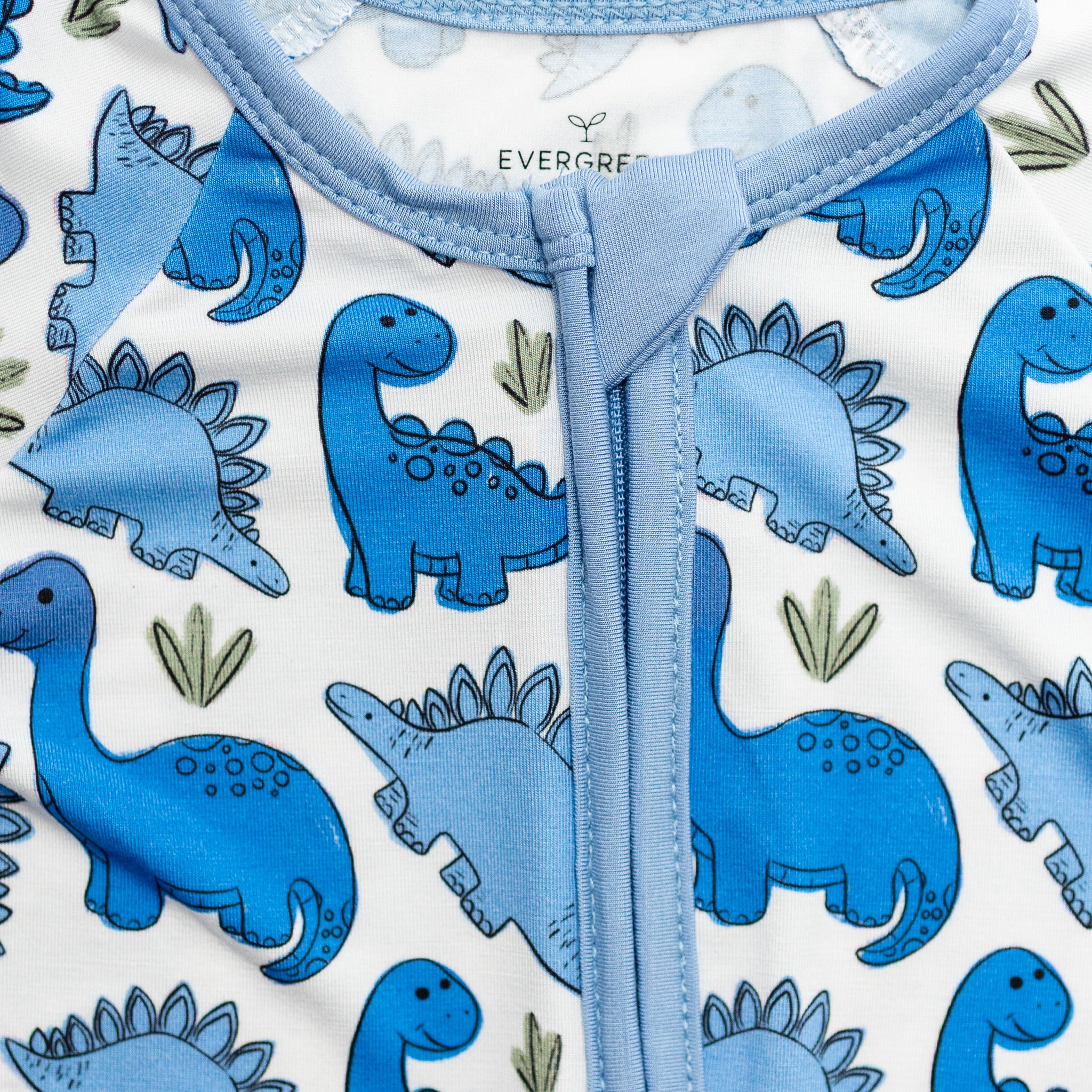 blue dinosaurs on white bamboo fabric pajamas neckline.
