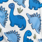 Pattern of blue dinosaurs on white bamboo fabric pajamas.