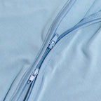 Close-up of a blue zipper on blue bamboo fabric.