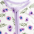 Close-up of a purple zipper on a white background with floral pattern bamboo fabric.