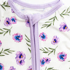 Close-up of a purple zipper on a white background with floral pattern bamboo fabric.