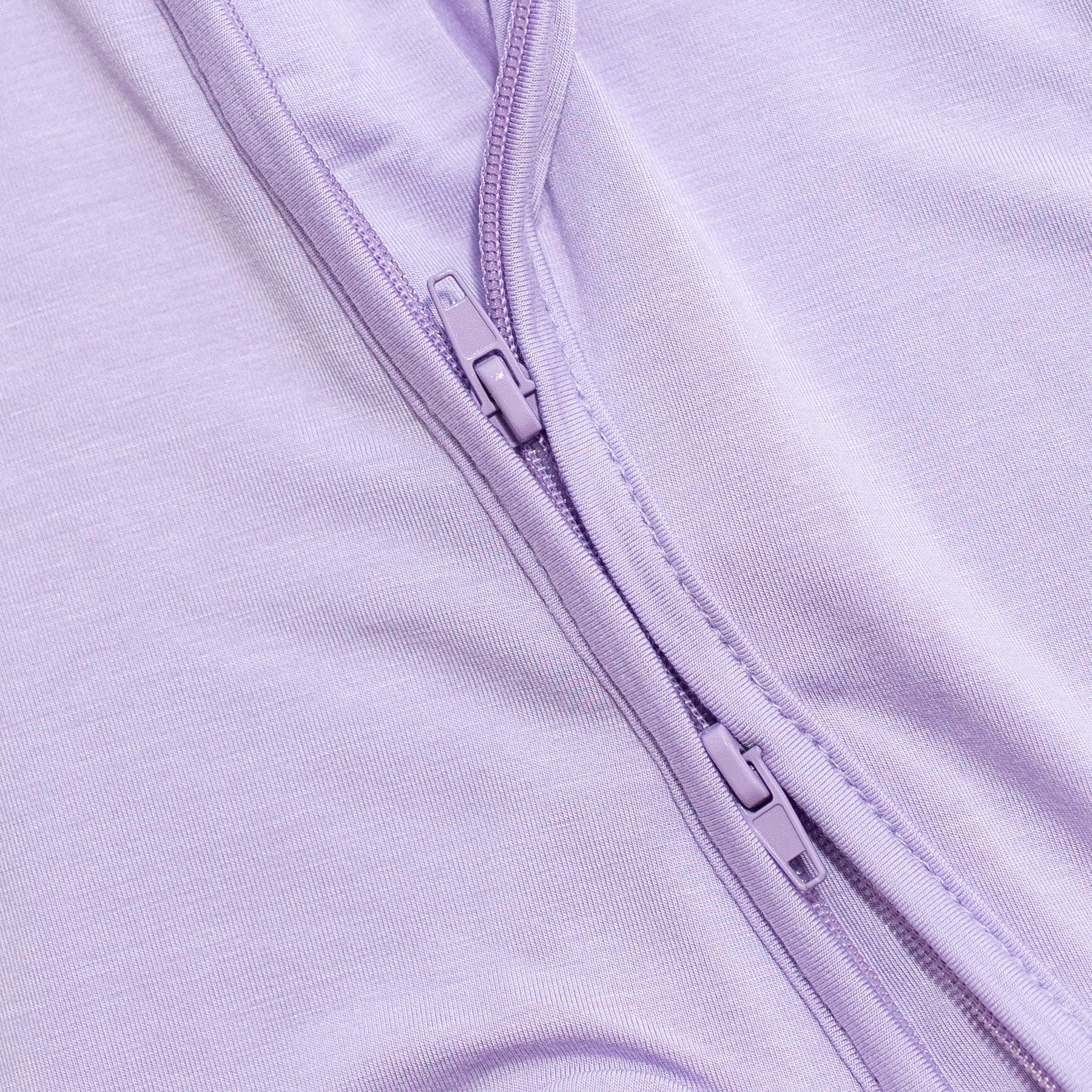 Close-up of a purple zipper purple bamboo pajama fabric.